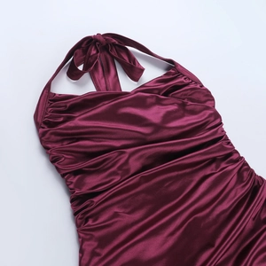 Détail de la robe licou en satin bordeaux montrant la texture plissée et brillante