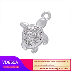 Macro detail of a 0.4g turtle charm VD869A with white zircon inlay on brass base