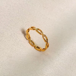 Minimalist gold chain-link titanium steel ring for women in a 45-degree top view