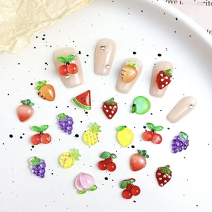 Macro shot of 3D fruit nail art charms with glitter finish for DIY manicure decoration