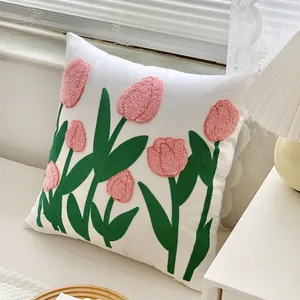 Modern French floral throw pillow with pink tulip embroidery on a cream fabric base