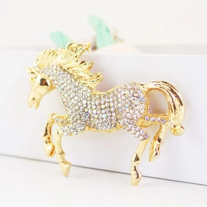 Sparkling crystal rhinestone galloping horse metal keychain in gold finish on white
