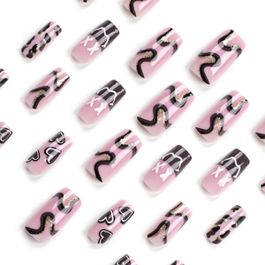 Coffin shaped press-on nails with heart patterns and kaws-inspired xx eye artistic design