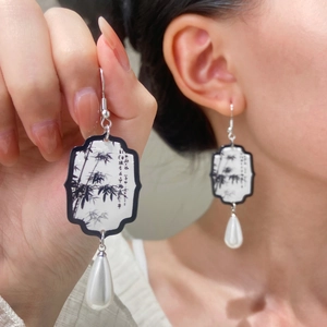 Detailed view of fan-shaped window earrings with ink bamboo pattern and teardrop pearls