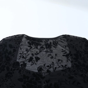 Gros plan sur un tissu en mesh noir transparent avec des motifs floraux en velours