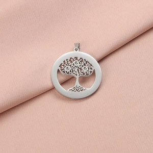 Dettaglio ravvicinato del ciondolo Albero della Vita in argento su tessuto rosa morbido