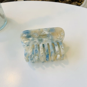 Detail of blue and beige marble acetate hair claw clip with golden Barrette La France text