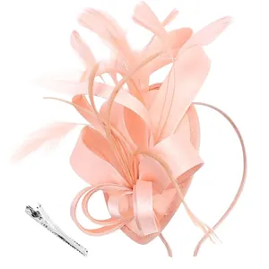 Detailed view of peach pink fascinator showing satin ribbons and feather craftsmanship