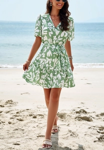Detail view of a green floral shirt dress with short sleeves and elegant waist tie details