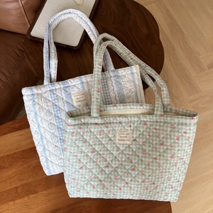 Detailed close-up of quilted floral cotton tote bags with vintage patterns and fabric labels