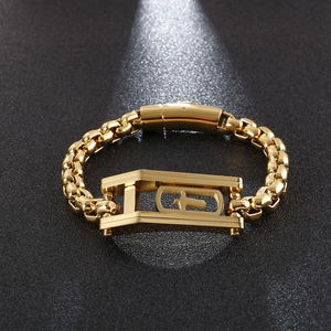 Detail of 18K gold plated hip hop bracelet featuring geometric cross links on dark background