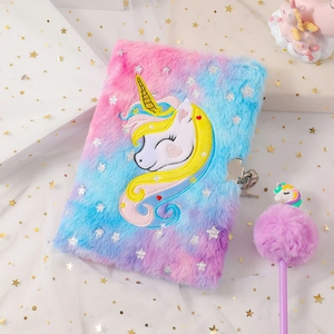 Detail of plush unicorn diary set with silver stamping and pom-pom pen on white tulle