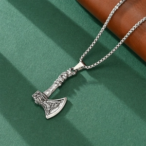 Detailed close-up of a silver axe pendant with embossed texture on a box chain