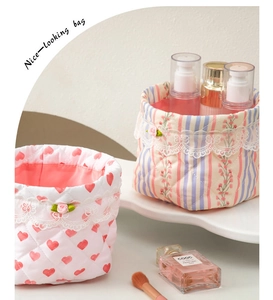 Close-up of quilted fabric storage baskets with lace trim and heart floral patterns