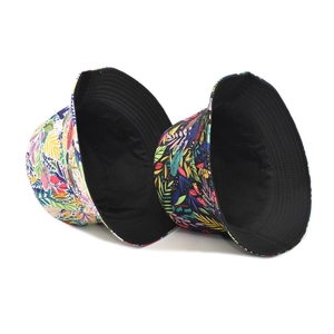 Reversible bucket hat with colorful tropical leaf print and solid black inner lining