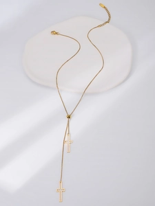 Macro shot of adjustable Y-shaped gold necklace with hollow cross pendants and slider bead