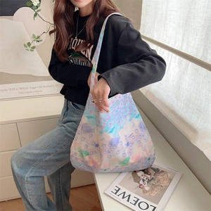 Detailed close-up of large canvas tote bag with purple floral print in home setting