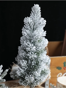 Macro detail of artificial mini Christmas tree with white snow flocking and natural pine shape