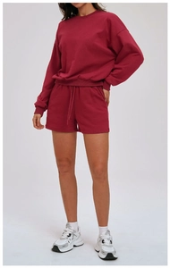 Detail of burgundy two-piece sweatshirt and drawstring shorts set with ribbed cuffs