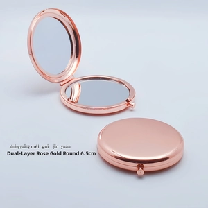 Close-up of 6.5cm rose gold metal foldable pocket mirror with dual side reflections
