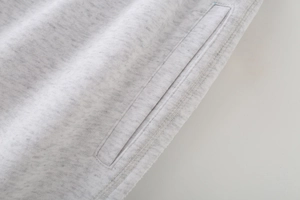 Macro shot of side pocket stitching and grey knit fabric texture on hooded tracksuit