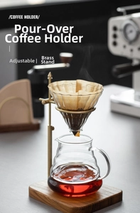 Detail of adjustable brass coffee dripper stand with solid wood base and glass carafe