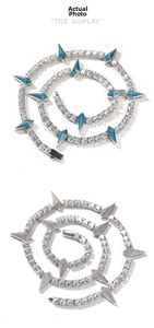 Macro view of iced-out hip hop tennis necklaces with blue spikes and zircon pavé detail