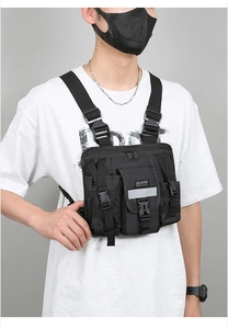 Detail view of black tactical chest bag with MOLLE system and reflective safety strip