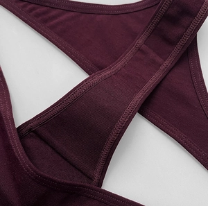 Detailed close-up of wine red cotton thong with criss-cross straps and fine stitching