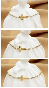 Detailed view of three gold-plated zircon cross tennis bracelets on elegant silk display