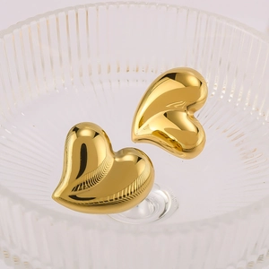 Polished 18K gold-plated puffy heart earrings in a glass dish for a stylish look