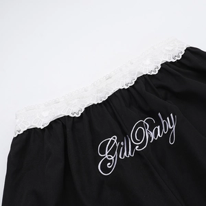 Détail de la bordure en dentelle blanche et broderie Girl Baby sur pantalon noir