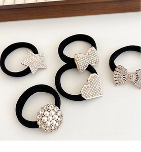 Detail of high-elasticity black hair ties with rhinestone hearts and pearl bow charms