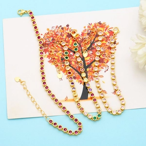 Detailed view of three gold-plated bracelets with colorful gemstones and heart-shaped charms