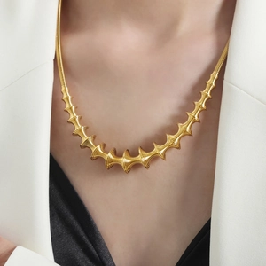 Baroque spiral spring necklace in gold finish worn by model with minimalist style