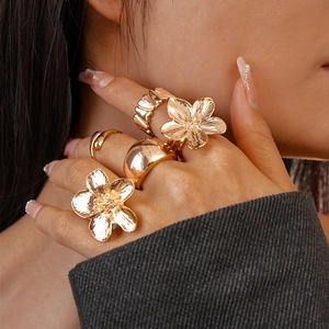 Close-up of five-piece gold flower ring set with wavy and dome texture details