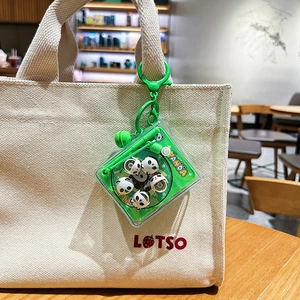 Cute green panda puzzle keychain accessory attached to a canvas bag with hook