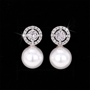 Detail of luxury pearl earrings with micro-set zircon accents and shimmering finish