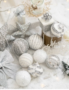 Detail of silver Christmas tree ornaments with sequins and stars on snowy background