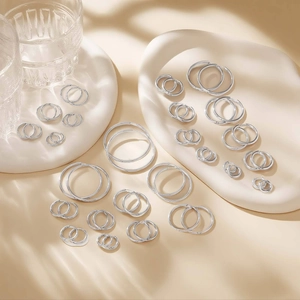Macro shot of multiple sizes polished silver stainless steel hoop earring set on tray
