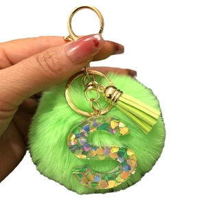 Resin letter S keychain with green faux fur pompom and colorful heart sequins
