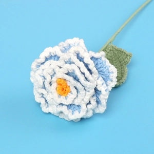 Macro detail of hand-knitted blue and white gradient peony flower with texture