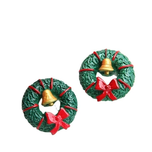 Christmas wreath earrings with red bows and gold bells on a clean white background