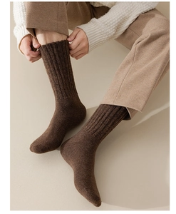 Detailed texture of thick brown thermal wool socks with ribbed knit pattern for men
