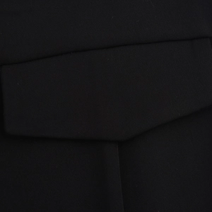 Detailed close-up of black twill fabric texture and stitching on the dress waist