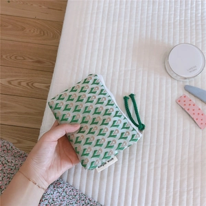 Détail d'une mini pochette en toile jacquard à motifs cœurs avec fermeture à glissière verte