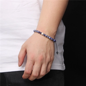 Detail of 6mm blue marble natural stone beads on an adjustable hand-woven cord bracelet