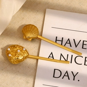 Detailed macro view of 18K gold plated seashell and scallop hair clips with pearls