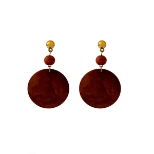 Macro view of geometric round dark wood pendant earrings with gold metallic stud detail