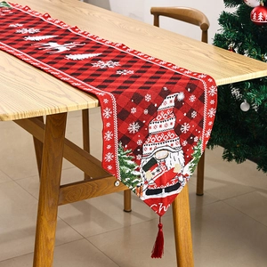 Detail of red and black buffalo plaid Christmas table runner with gnome embroidery and tassels